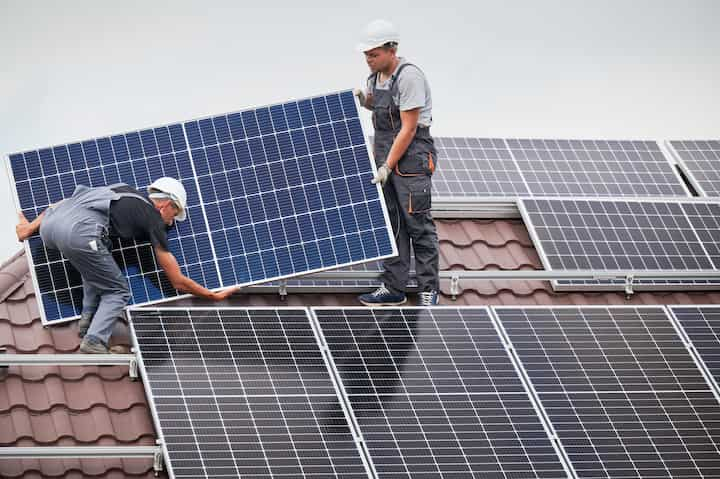 Expert solar panel installations work on residential home.